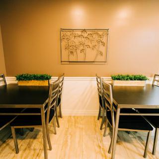 A cozy dining space with tables, chairs, and decorative plants.