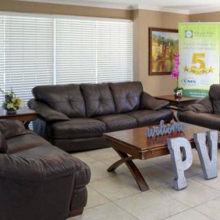 A cozy living room with dark brown sofas and a wooden coffee table.