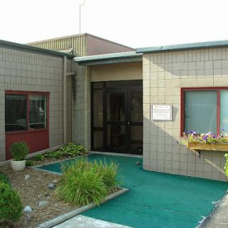 An exterior view of a well-maintained building entrance with landscaped areas.