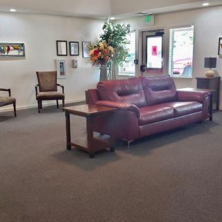 A well-furnished lobby featuring a comfortable sofa, chairs, and decor elements like indoor plants.