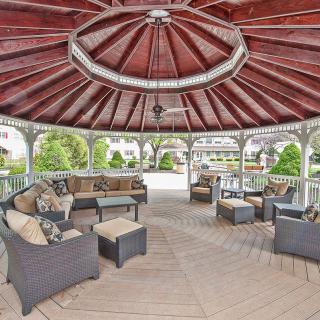 A spacious gazebo with comfortable seating and a garden view.