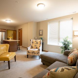 A cozy living room featuring a stylish sofa, colorful armchair, and ample natural light.
