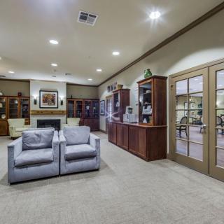 A spacious living room featuring comfortable seating, wooden bookshelves, and a cozy fireplace.