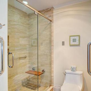 A modern bathroom with a glass-enclosed shower and a toilet.