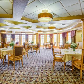 Elegant dining room with well-arranged tables, chairs, and decorative lighting.