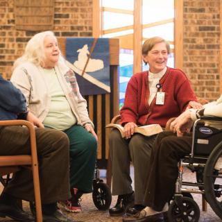 A group of seniors having a discussion in a cozy indoor setting.