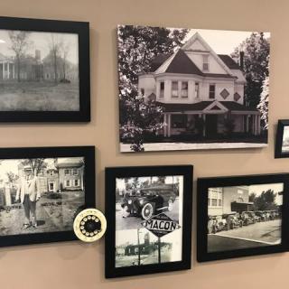 A collection of vintage black-and-white photographs displayed in frames on a wall.