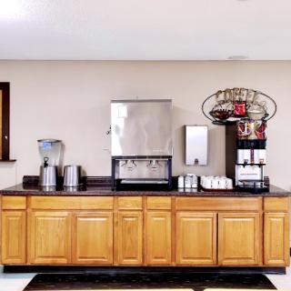 A well-organized beverage station featuring a coffee machine, water dispenser, and ample storage.