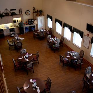 A spacious dining area with neatly arranged tables and a view of the kitchen.