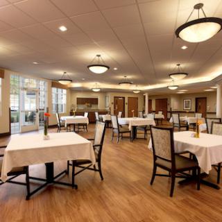 A spacious and elegantly designed dining area featuring neatly arranged tables and ambient lighting.
