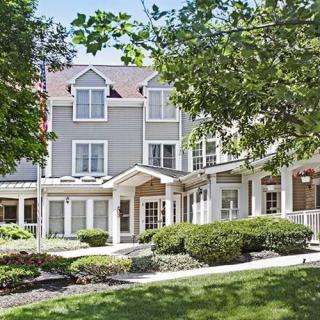 A residential building with well-maintained landscaping on a sunny day.
