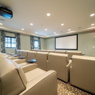 A luxurious home theater with comfortable seating and a large screen.