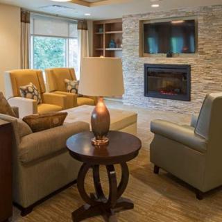 A cozy living room featuring comfortable seating, a fireplace, and a mounted television.