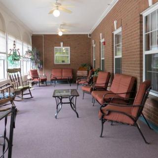 A cozy sunroom with comfortable seating and large windows.
