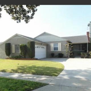 A suburban house with a well-maintained lawn and a driveway leading to a garage.