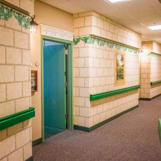 A hallway with brick-patterned walls, green accents, and festive decorations.
