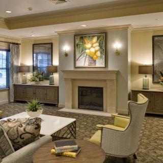 A modern and elegantly designed living room featuring a central fireplace, comfortable seating, and tasteful artwork.