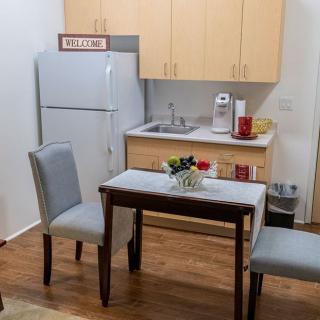 A small kitchen and dining area with a table, two chairs, and a refrigerator.