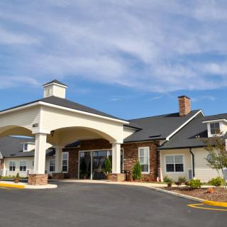 A modern building with an arched entrance under a clear blue sky.