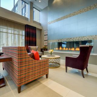 A modern living room with a high ceiling, featuring a stylish fireplace and contemporary furniture.