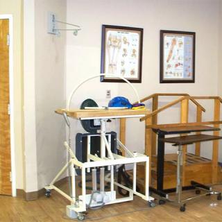 Physical therapy room with exercise equipment and anatomical charts.