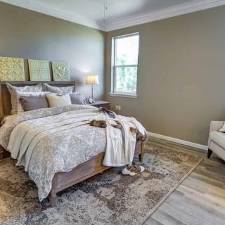 A cozy bedroom decorated with neutral tones, featuring a comfortable bed and stylish furnishings.
