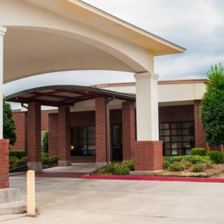 A modern building entrance with an archway and landscaped surroundings.