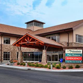A modern hospital building with an emergency entrance.