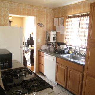 A cozy kitchen featuring wooden cabinets, a gas stove, and essential appliances.