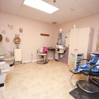 A cozy and well-equipped salon interior featuring hairdressing chairs, mirrors, and beauty equipment.