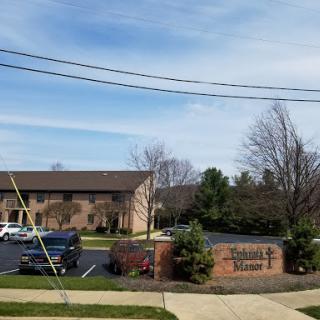 A view of a residential apartment complex with landscaped grounds and a clear blue sky.