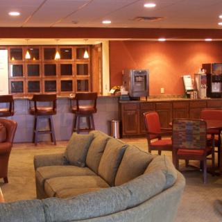 A cozy lounge area with comfortable sofas, chairs, and a bar setup.