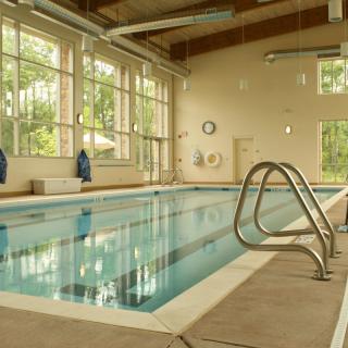 An inviting indoor swimming pool with large windows letting in natural light.
