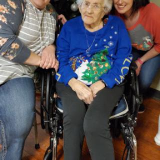 A joyful family moment with an elderly woman in a wheelchair, celebrating together.