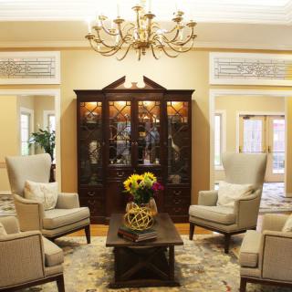 Elegant living room with armchairs and a chandelier.