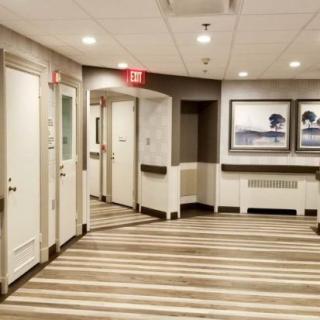 A modern hotel hallway with striped flooring and wall art.