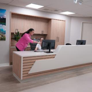 A receptionist preparing at a modern office desk.