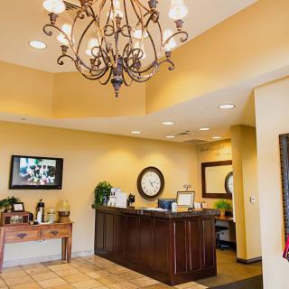 A welcoming hotel reception area with a chandelier and front desk.