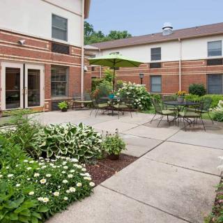 A peaceful courtyard with outdoor seating and lush greenery.