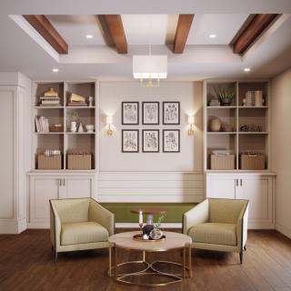 A stylish living room featuring two armchairs, a round table, built-in bookshelves, and decorative wall art.