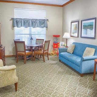 A cozy living room with a blue sofa, a dining table, and decorative elements.