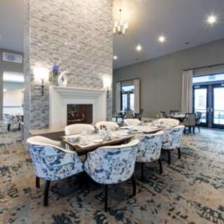 A beautifully designed dining room featuring a fireplace, elegant lighting fixtures, and stylish chairs around a large table.