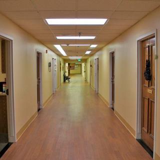 A well-lit indoor hallway with doors on both sides.