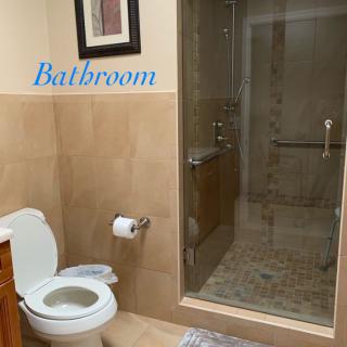 A clean and modern bathroom with a toilet and a glass-enclosed shower.