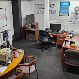 A view of a neat and organized office workspace with desks, computers, and seating arrangements.