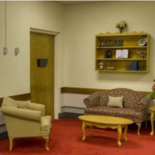A small waiting area with a sofa, armchair, and coffee table.