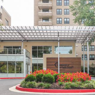 A modern building entrance with a landscaped garden and vibrant flowers.