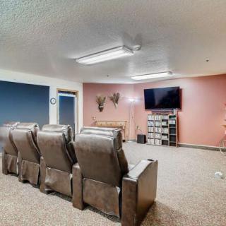 A cozy home theater with recliner seating and a wall-mounted TV.