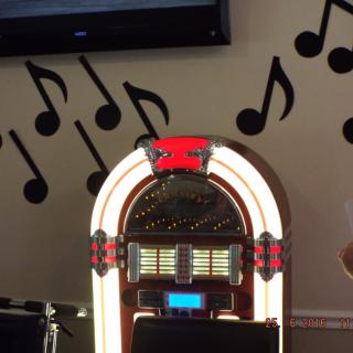 A vintage jukebox with surrounding musical note wall art.