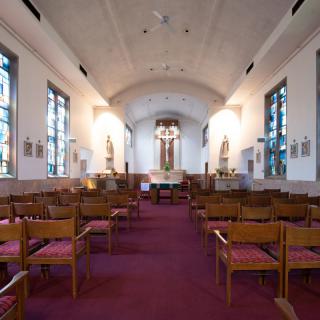 Interior view of a church with wooden pews and an altar at the front.